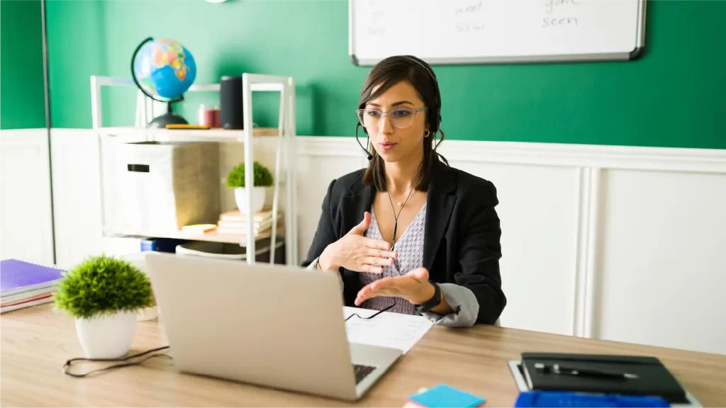 Tutora en línea impartiendo una clase virtual desde su área de trabajo organizada
