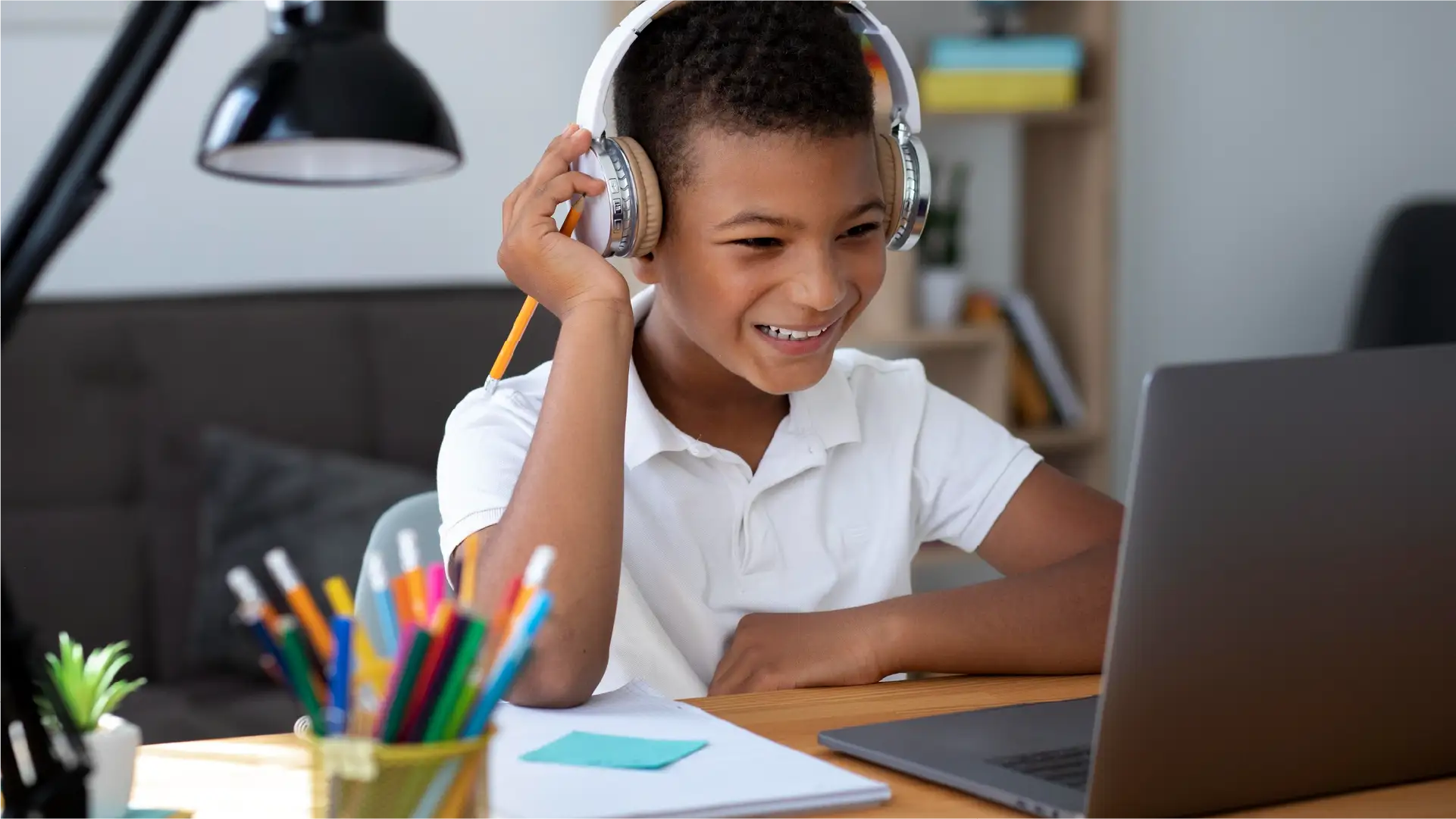 Estudiante joven disfrutando de una clase en línea o curso virtual con auriculares y computadora portátil